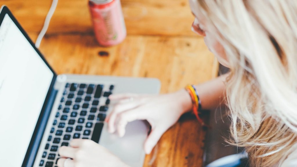 Giovane donna che scrive al computer